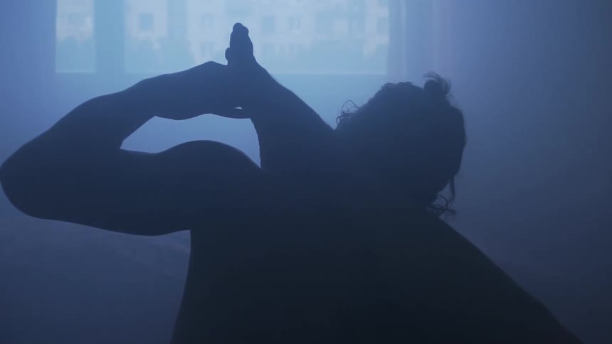 A woman is stretching in a room