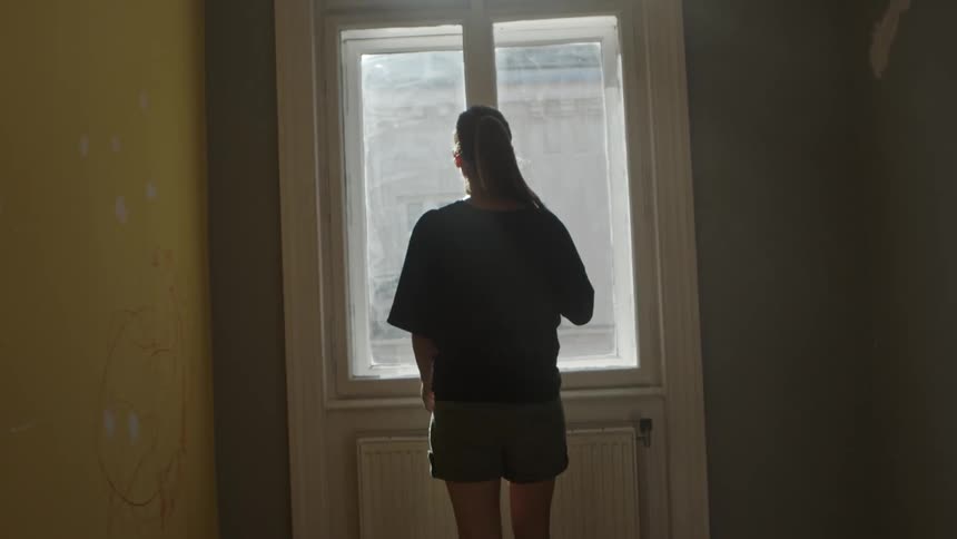 A woman is walking in an empty house