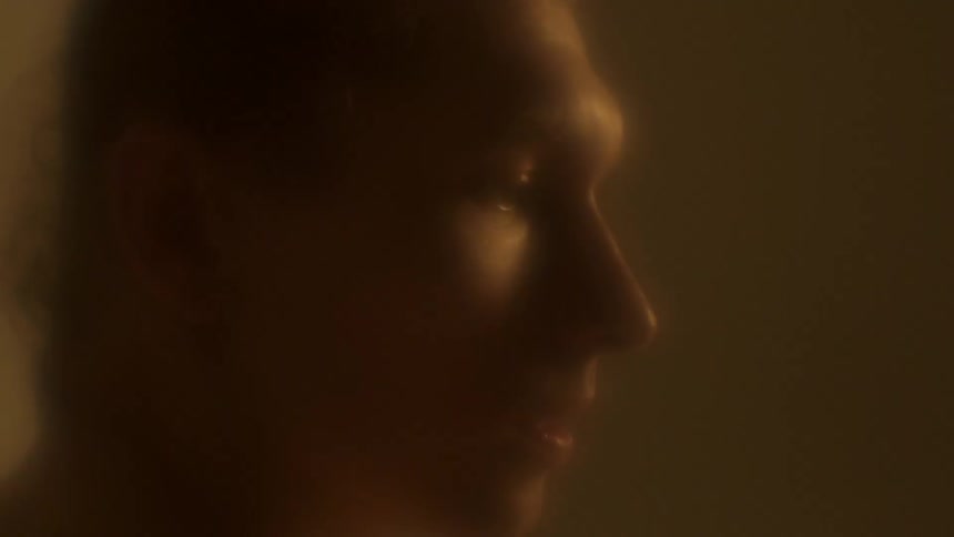A man is in profile in a dim room