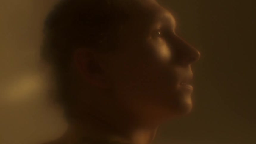 A man indoors looks off in to the distance