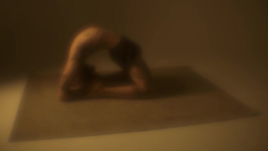 A woman does a back bend as she exercises