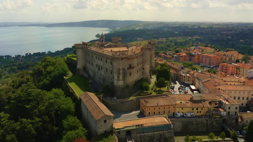 A castle atop a hill on the coast looms over the surrounding town and countryside