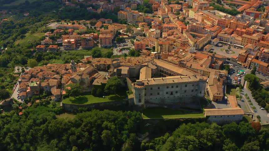 Aerial view of a city set on hills and greenery during the day in summer