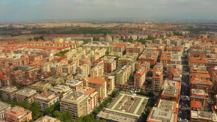 A city with buildings trees streets and vehicles with the sky and clouds in the background