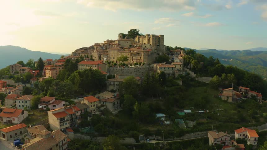 Houses and a town on a hill with mountains in the background