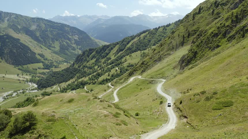 A vehicle driving on a road through the hills