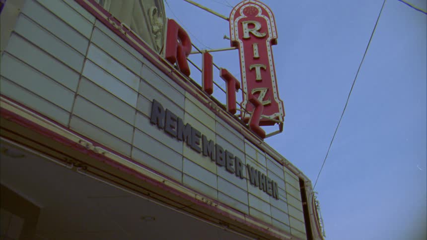 An old marquee over the entrance to a theater in a city during the day