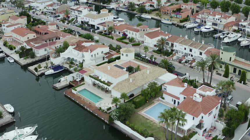 Boats sit outside sprawling homes along the coast