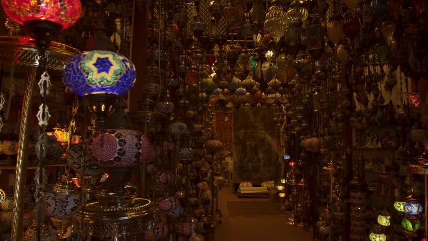 A passing view of the interior of a cluttered exotic lamp shop in the daytime