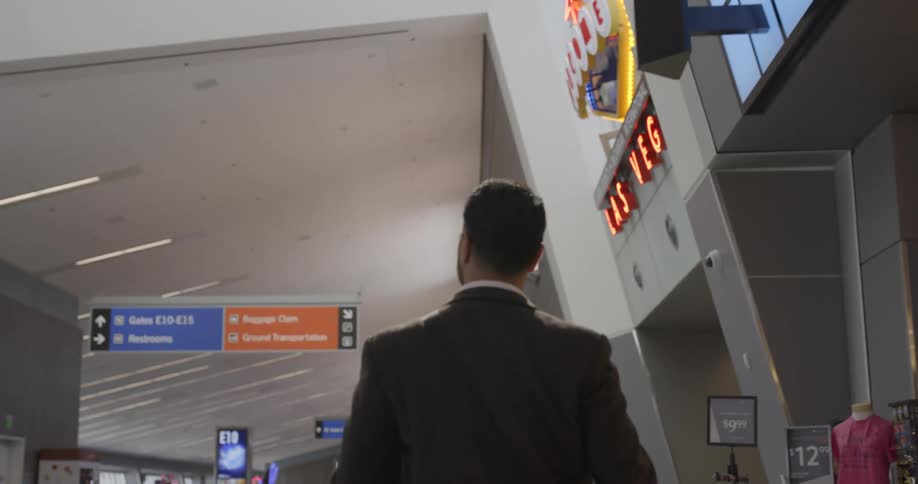 Man walks through terminal passing others as he nears waiting area