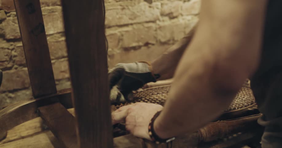 A man cleans the back of a carved wooden chair