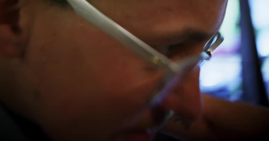 Close up of a white man looking closely at something