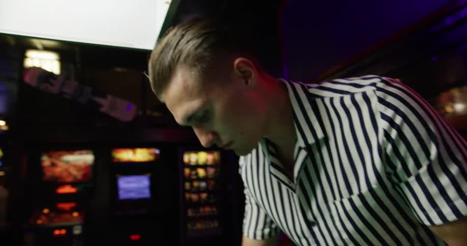 A white male racking a pool table in a bar