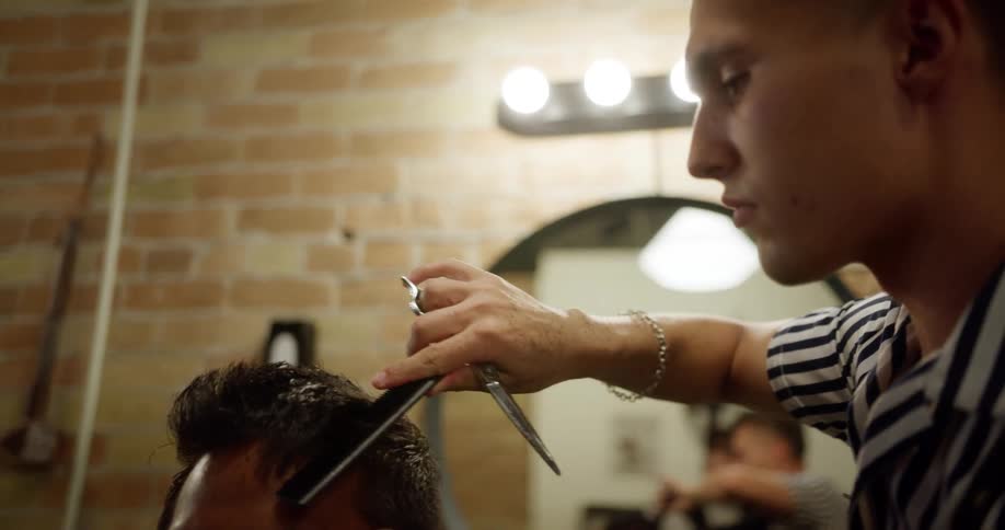 A male hairdresser cuts a mans hair