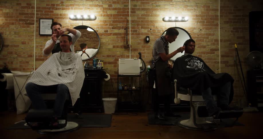 Two men in a barber shop getting a hair cut
