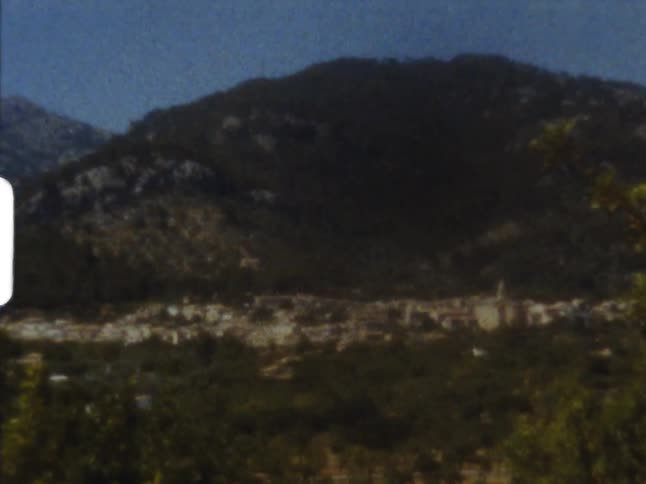 Town sits at the bottom of the small mountain with othersmall mountains behind it just visible on 8mm