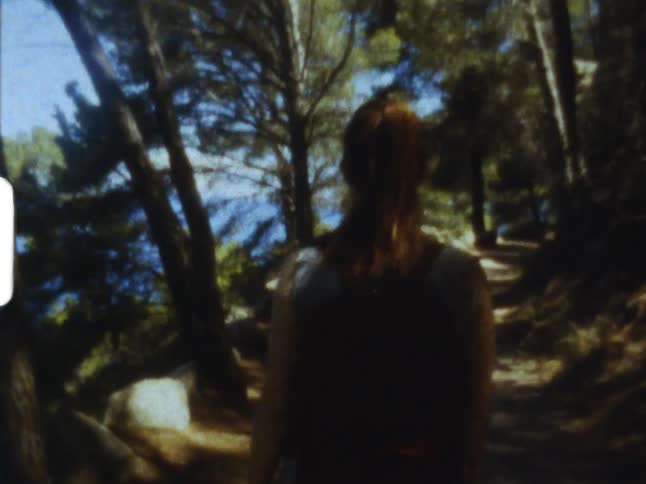 A young girl walking through a forest on 8mm