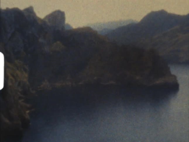 A lake with a mountain range the sky and clouds in the background on 8mm