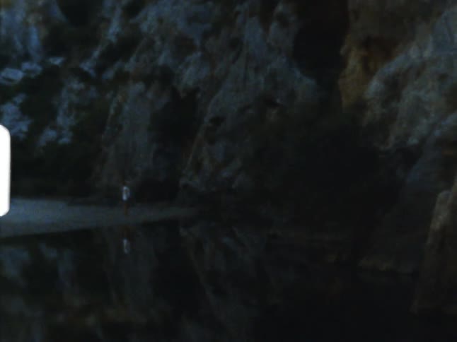 Person stands in water next to seaside cliffs on 8mm