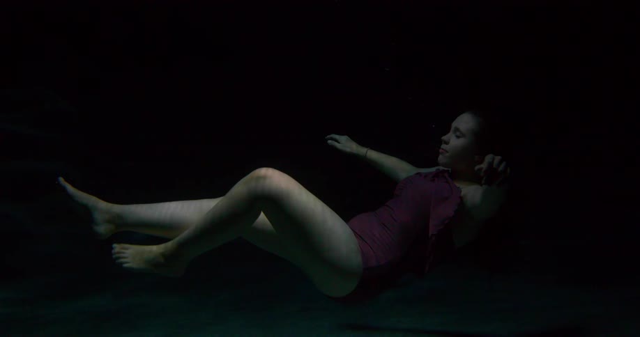 Woman floating in water with eyes closed