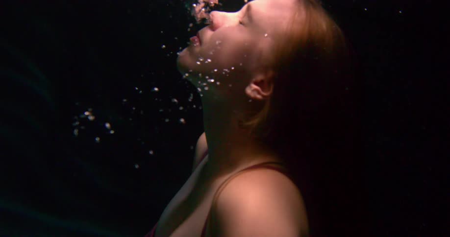 A girl swims back up to the surface of her pool