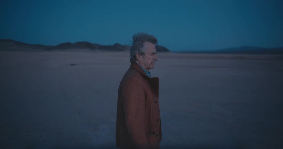 A man is walking in a rural area at dusk