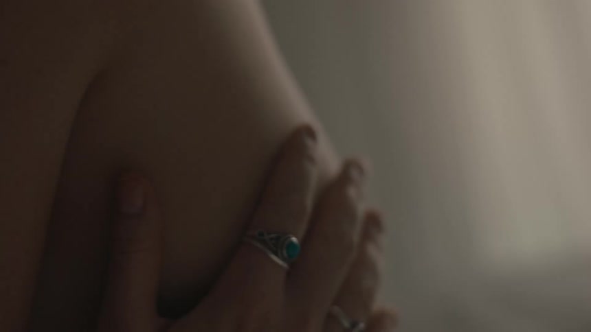 A persons hand with rings touching their body
