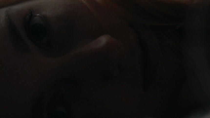 Close up of a womans face lying down in the dark