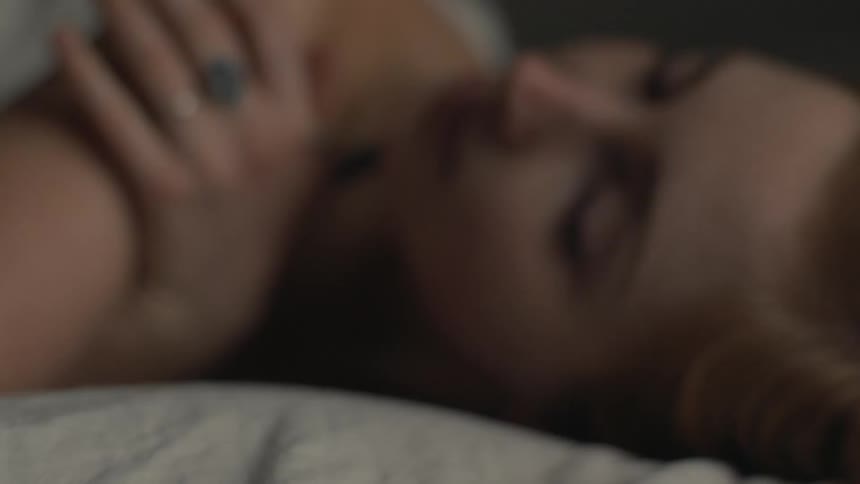 A woman is laying on a bed indoors