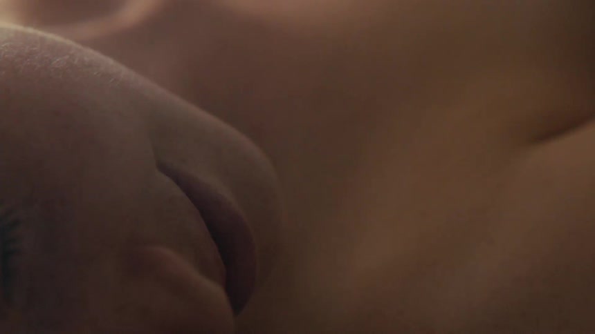 A woman lies down while topless