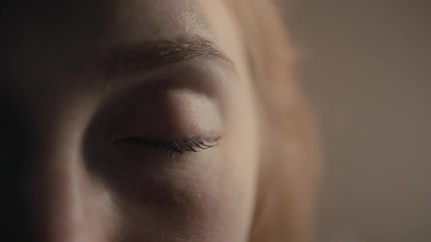 A young woman opening and closing her eye