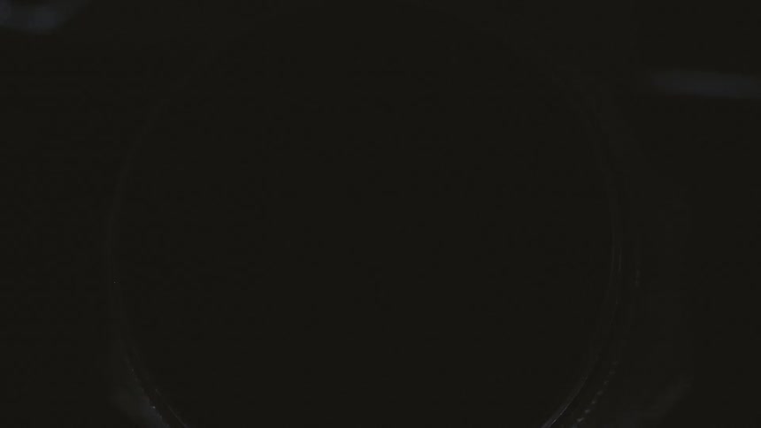 A camera lens with letters and numbers and light reflecting on it