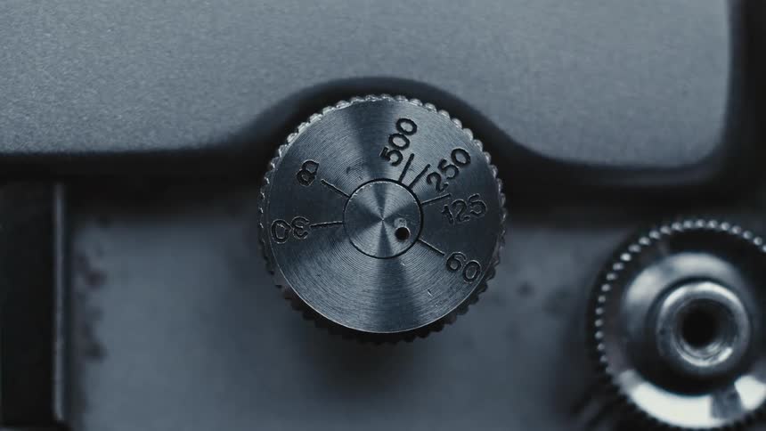 A man pushes a button on a camera and a dial turns