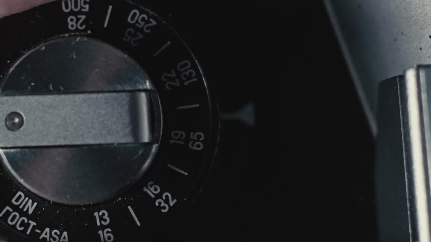 Person adjusts black dial with numbers and marks around metal center piece
