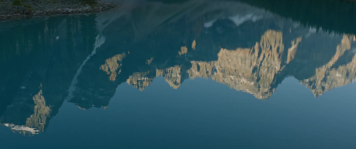 Snowy mountains reflected on a lake surface on a winter day