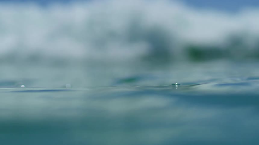 Ocean waves are flowing and crashing in the sea on sunny day