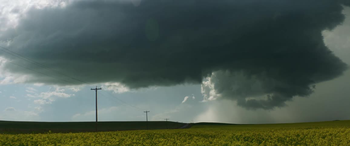 Dark cloud hovering over a field in the country side