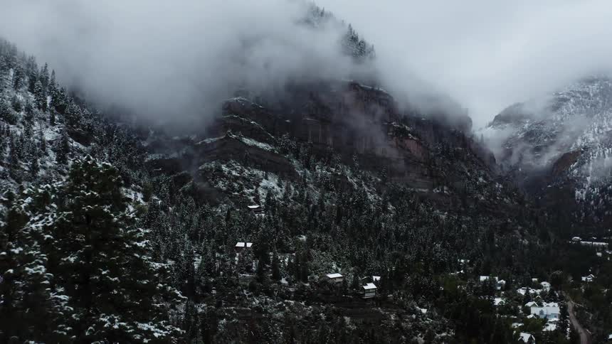 Homes sit on the slope of a mountain range in the country