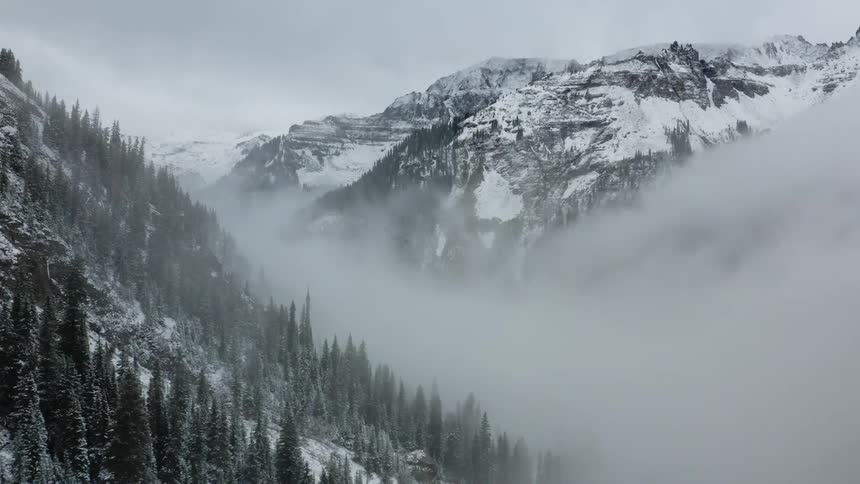 Heavy fog sets over snow covered mountains