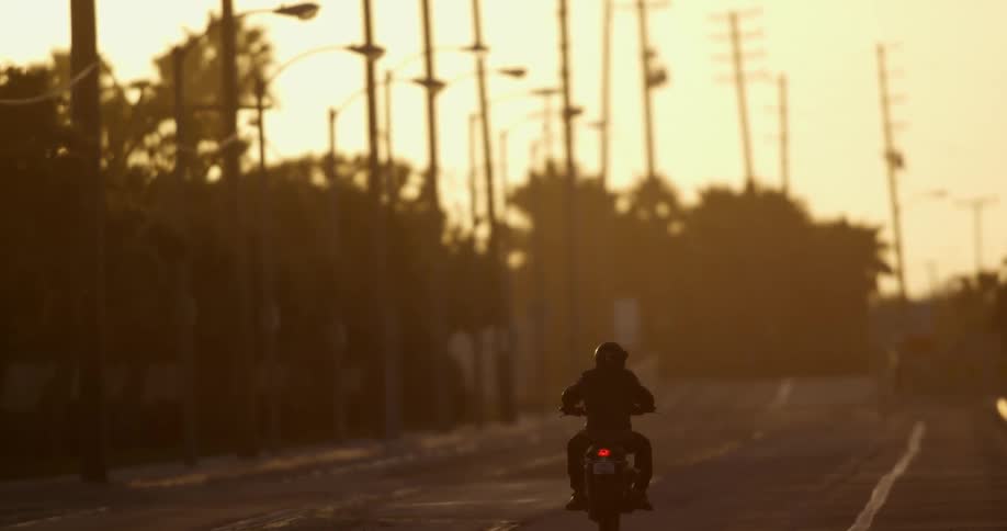 A person rides a motorcycle alone on a large highway