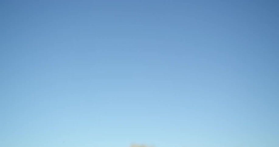 A person taking off on a dirty motorcycle in the daytime