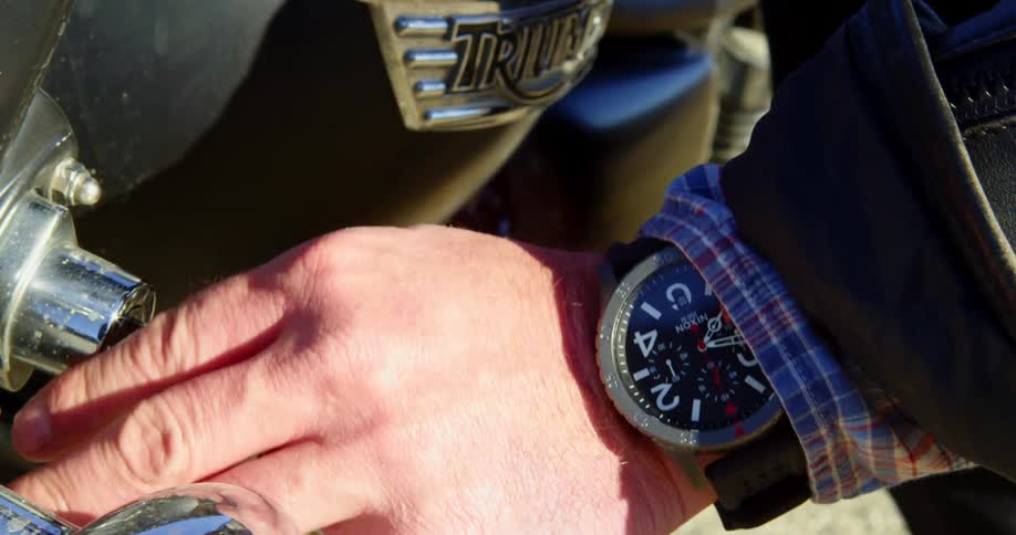 Person inserts key in ignition of triumph motorcycle
