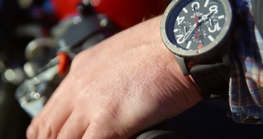 A man puts his hand over the handle of a motorcycle and test the brakes