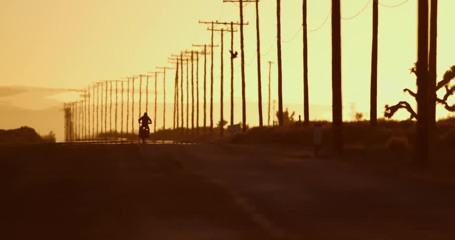 A person is riding a motorcycle at dusk
