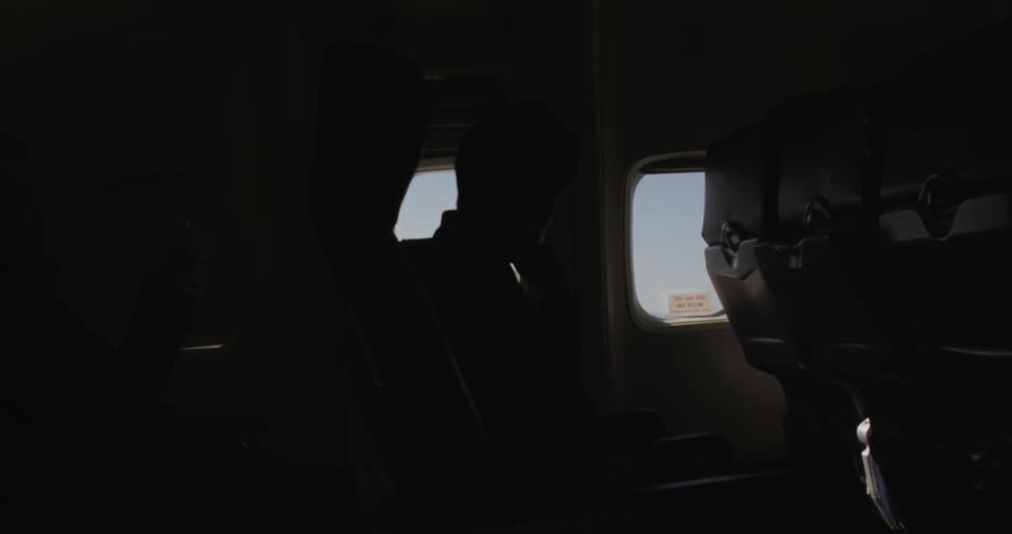 The inside of a cabin is dark with only one person visible