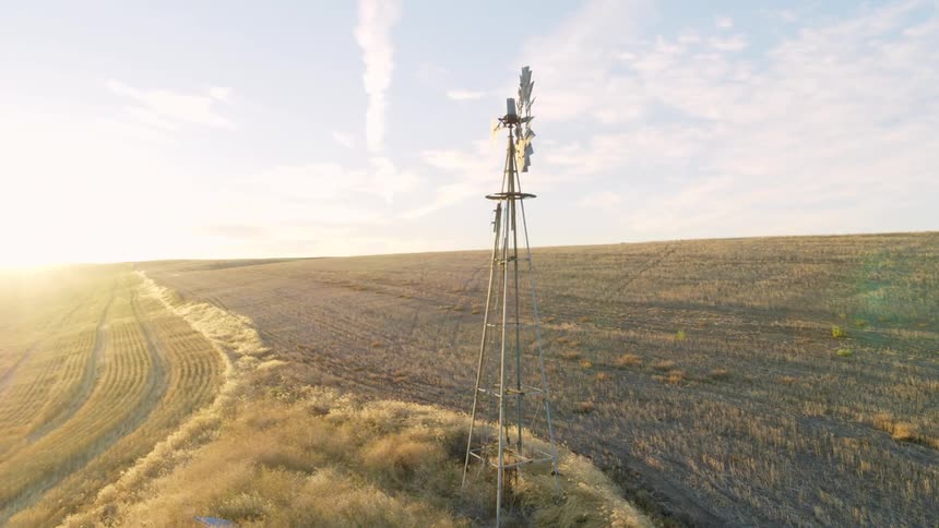 Parallax move around a classic windmill to reveal the sun rising over farmland