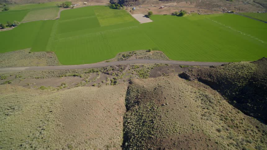 Revealing green farmland nestled within a deep valley gorge on a bright summer day