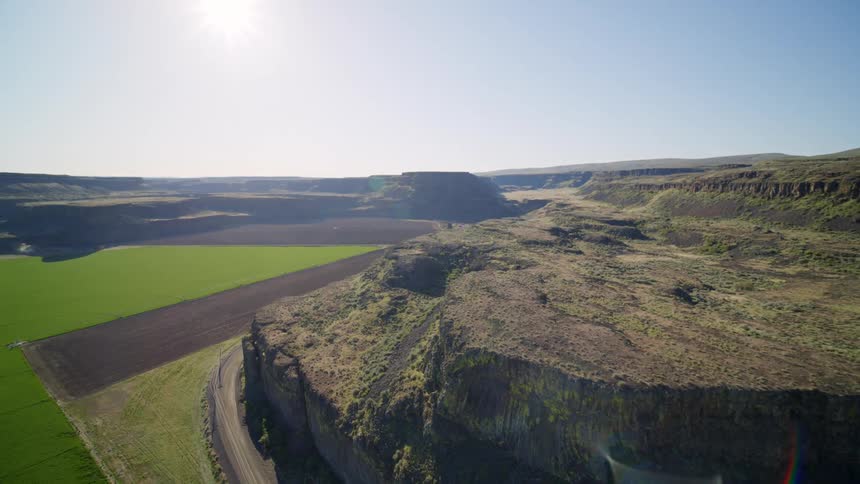 Reveal of new crops growing in a valley surrounded by dramatic cliffs and canyons