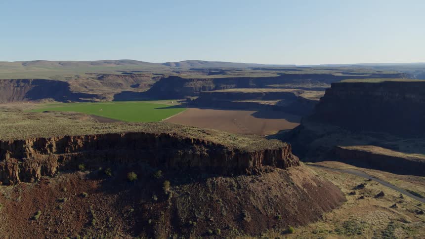 Revealing a valley of fertile farmland from behind rugged cliffs and tall plateaus