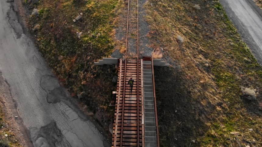 A person walking along a railway track